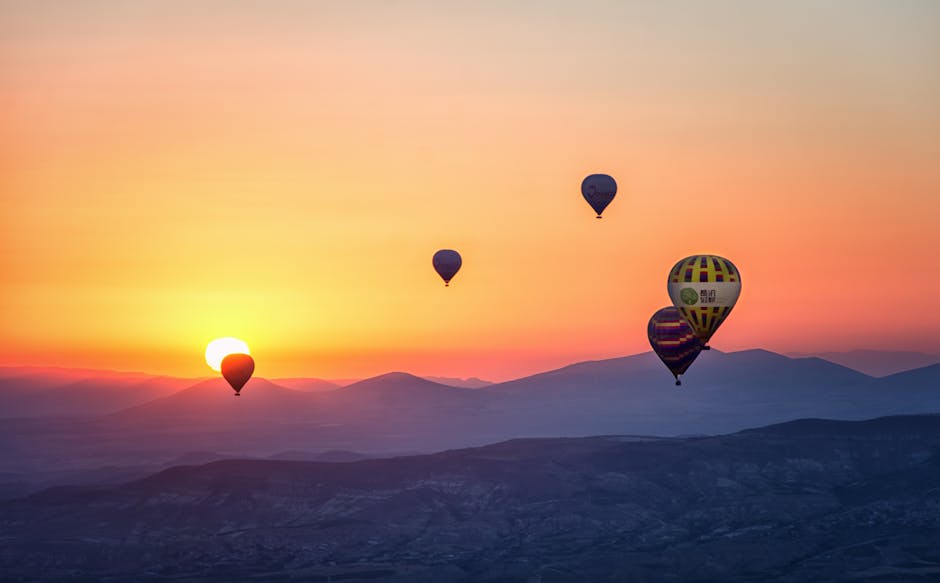 Hot air balloons rising at sunrise